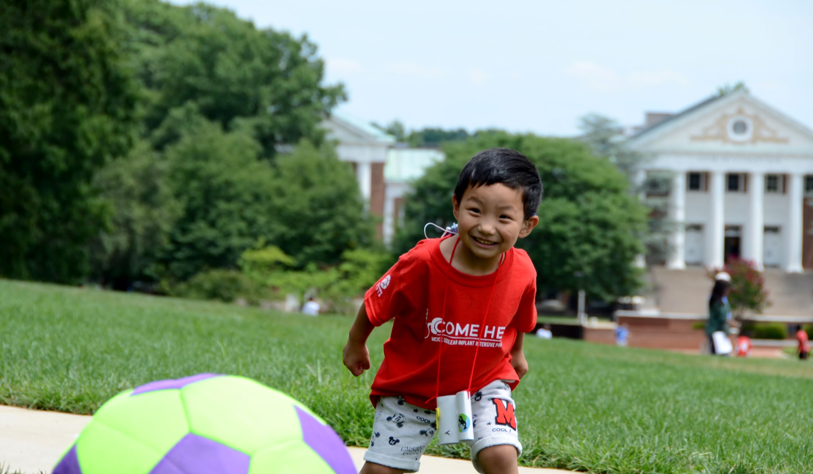 Child with CI at MCICE Summer intensive program playing with soccer ball