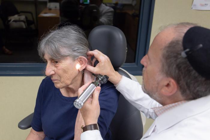 A male doctor looks in a woman's ear
