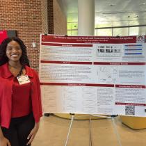 Reach student standing with their poster titled "The Relative Importance of Vowels and Consonants for Sentence Recognition"
