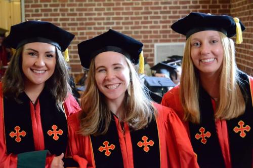 3 graduates in cap and gowns