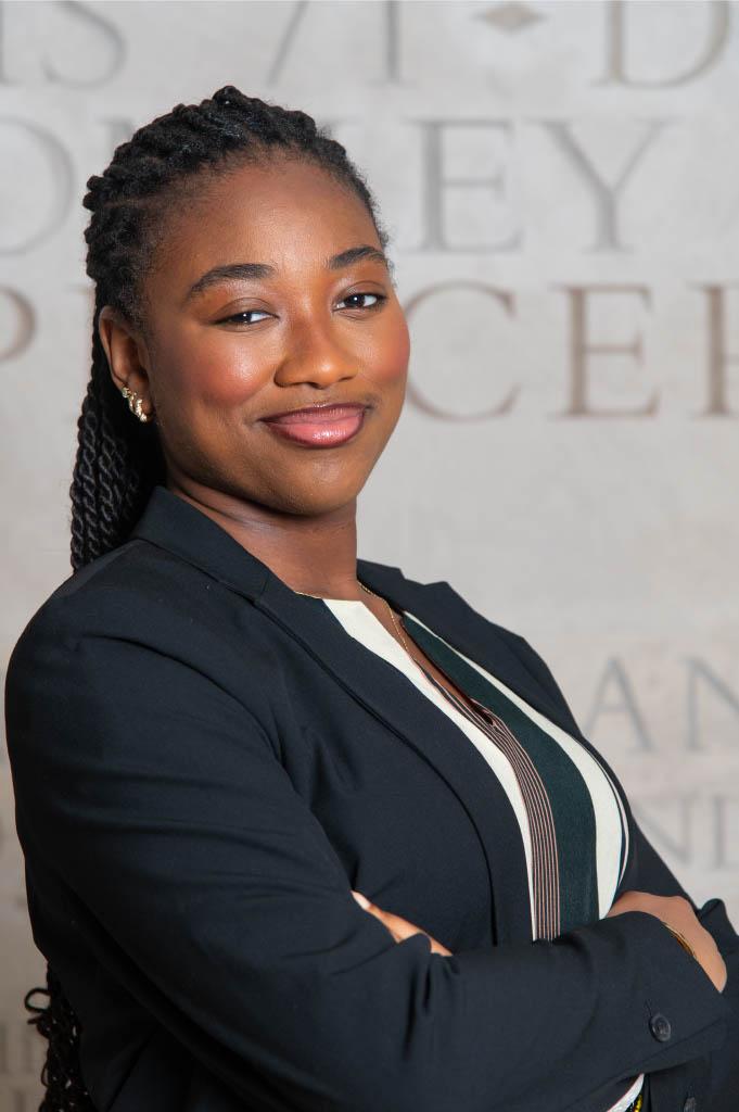 image of a young Black woman in a navy blue blazer acing towareds the left for a professional photo