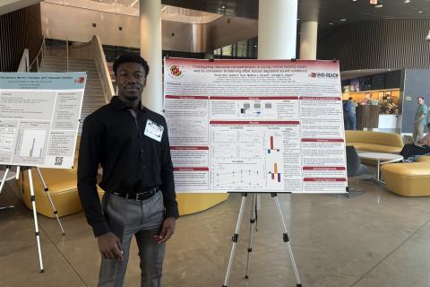 Gerald Tabe posing next to her poster at the 2025 Poster Session
