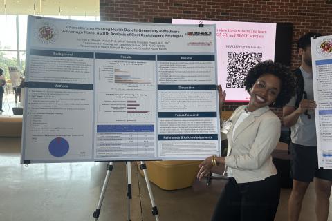 Joy Sharp posing next to her poster at the 2025 Poster Session