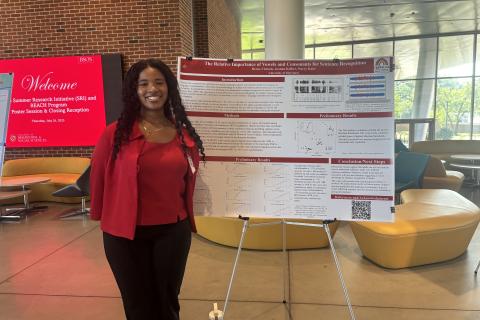 Renée Christie posing next to her poster at the 2025 Poster Session